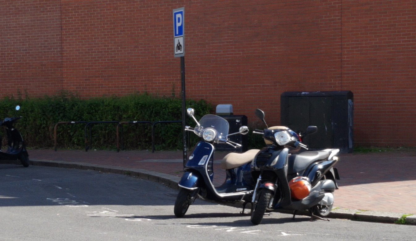 couple of scooters in big, spacious motorcycle parking bay